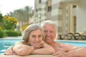 casal de idosos na piscina do hotel